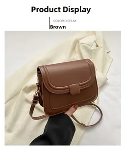 Petit sac carré marron en cuir avec bandoulière réglable sur une veste beige chic