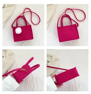 Detailansicht der fuchsiafarbenen gesteppten Filztasche mit weißem Bommel und Gurt