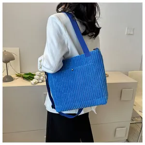 Borsa tote in velluto a coste blu in una foto lifestyle con arredo ufficio minimalista