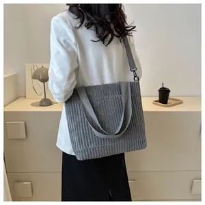 Dettaglio borsa shopper in velluto a coste grigio con tracolla e trama a righe