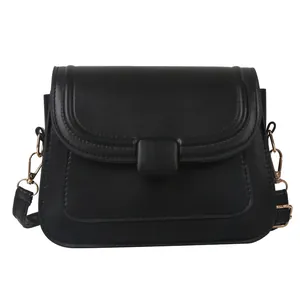 Sac bandoulière minimaliste en cuir PU noir avec rabat et boucle dorée sur fond blanc