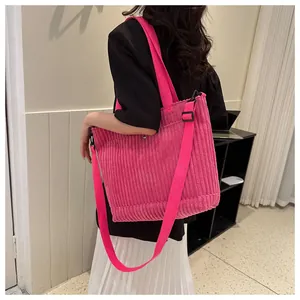 Dettaglio della borsa tote in velluto a coste rosa con trama a righe e tracolla larga