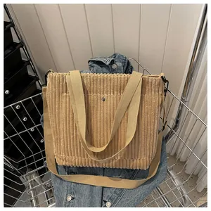 Dettaglio della borsa tote in velluto a coste giallo con texture e fibbia in metallo