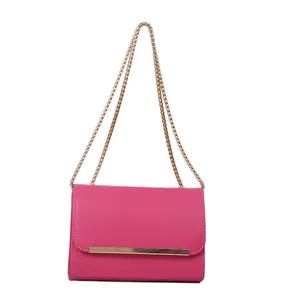 Minimalist fuchsia leather crossbody bag with elegant gold chain and bar clasp