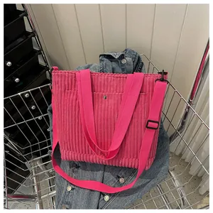 Dettaglio della trama della borsa tote in velluto rosa con tracolla regolabile