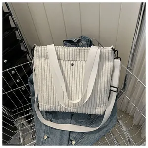 Dettaglio della borsa tote in velluto a coste bianco con tracolla e fibbia in metallo