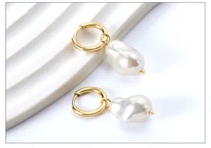 Makroaufnahme eleganter Gold-Creolen mit unregelmäßigen weißen Barockperlen