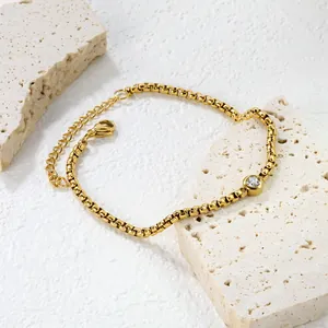 Bracciale a catena tonda dorata con zircone rotondo su piedistalli in pietra chiara