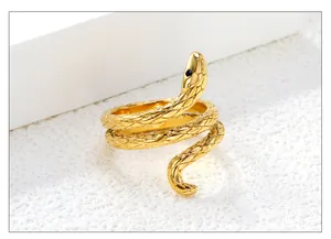 Detailed close-up of golden snake ring with scales and black gemstone accent
