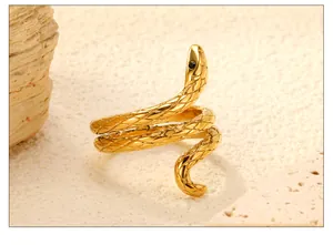 Macro detail of golden snake ring showing intricate scale textures and black stone eye
