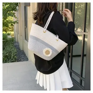 Detail of woven tote bag with 3D daisy flowers and white rope handle for summer fashion