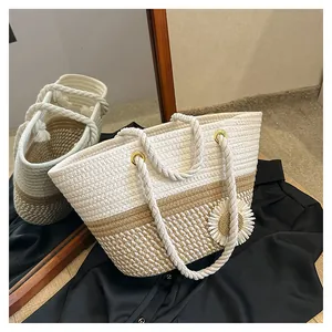 Detail of woven tote bag with thick cotton rope handles and daisy flower charm
