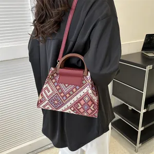Ethnic woven crossbody bag with diamond patterns and dark red leather straps for women