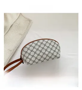 Vista dettagliata della pochette a mezzaluna con motivo a trifoglio grigio e finiture marroni