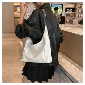 Détail d'un sac hobo blanc en similicuir avec bandoulière élégante en chaîne argentée