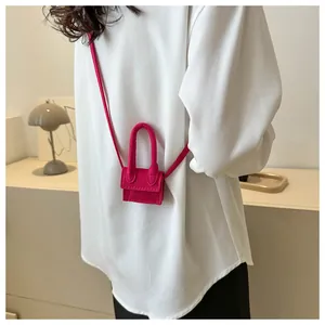 Detail of rose pink mini crossbody bag with soft felt texture and thin shoulder strap