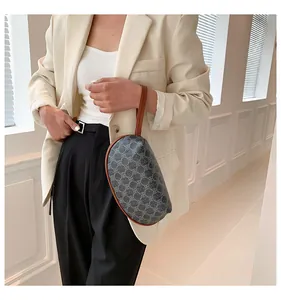 Elegante borsa a mezzaluna con motivi geometrici e cinturino da polso in pelle marrone