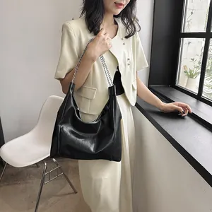 Sac fourre-tout noir minimaliste en similicuir avec chaîne argentée et plis latérux