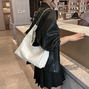 Chic sac hobo en similicuir blanc mat avec chaîne argentée porté à l'épaule