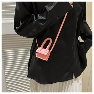 Pink micro felt shoulder bag shown on model with black shirt and white pleated skirt