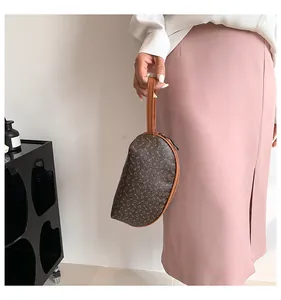 Vista dettagliata della pochette a mezzaluna con motivo geometrico e chiusura zip