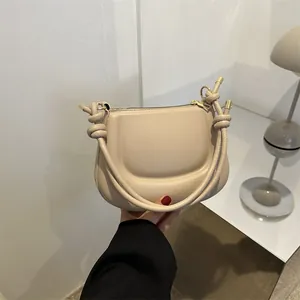 Borsa a sella beige minimalista da donna con manico decorativo a nodo e dettagli dorati