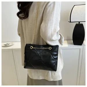 Vue détaillée du sac à bandoulière matelassé noir avec chaîne dorée sur un mannequin