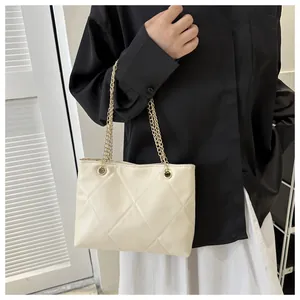 Détail du sac bandoulière beige matelassé avec surpiqûres losanges et chaîne dorée