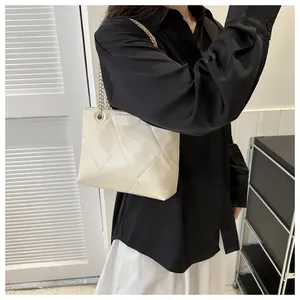 Gros plan du sac fourre-tout matelassé blanc cassé avec bandoulière en chaîne dorée