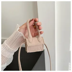Close-up of a micro camel suede crossbody bag with top handle and stylish flap design