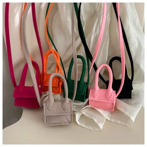 Detailed view of mini felt handbags in various vibrant colors with top handles and straps