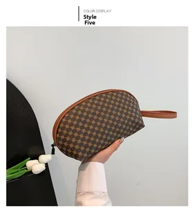 Dettaglio borsa Style 5 con motivo geometrico marrone, zip in metallo e cinturino in pelle