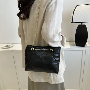 Sac à bandoulière matelassé noir avec chaîne dorée présenté sur mannequin pour taille