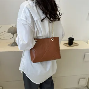 Sac bandoulière marron matelassé chic avec chaîne dorée dans un cadre de vie moderne