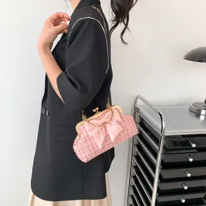 Sac coque en tweed rose avec nœud en satin et chaîne dorée pour un porté élégant