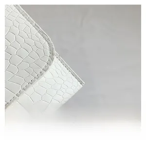 Close-up of white crocodile pattern leather handbag with precise stitching details