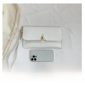 White crocodile pattern envelope clutch bag with gold V buckle and wrist strap detail