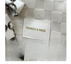 Détail de la texture à carreaux avec étiquette cuir FASHION & BAGS et foulard de soie
