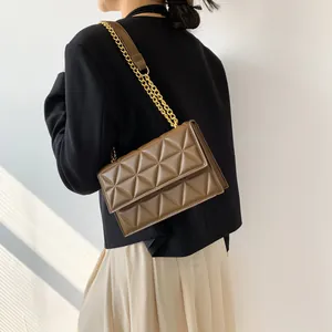 Dunkelbraune gesteppte Ketten-Schultertasche getragen von Modell vor Sonnenlicht