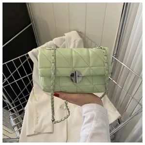 Détail du petit sac bandoulière vert clair avec fermoir rotatif et bandoulière chaîne