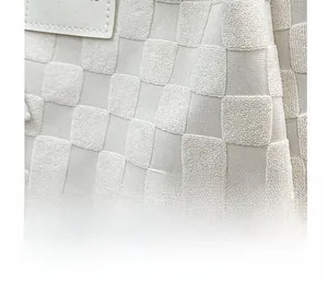 Détail de la texture damier en tissu bouclé crème sur un sac cabas vintage chic