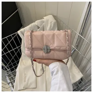Gros plan du sac bandoulière matelassé rose avec chaîne argentée et fermoir rotatif