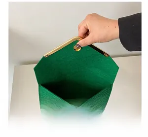 Detail view showing green felt fabric texture and gold metal edge with magnetic snap