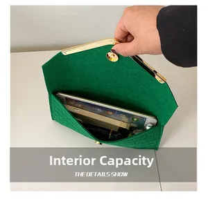 Internal capacity of green textured envelope clutch with metal snap closure and gold trim