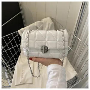 Détail du sac bandoulière matelassé blanc avec chaîne argentée et fermoir pivotant