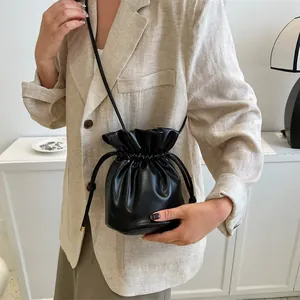 Minimalist black leather drawstring bucket bag for women with elegant crossbody strap