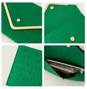 Detail view showing emerald green crocodile pattern envelope clutch and its interior capacity