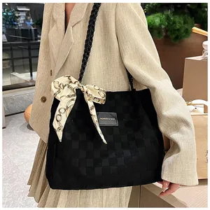 Détail du sac cabas tissé à damier noir avec un nœud décoratif en soie élégant