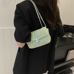 Sac bandoulière matelassé vert clair avec chaîne argentée porté par un mannequin