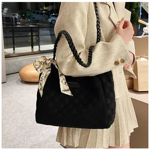 Détail du sac cabas en daim noir avec poignée en cuir tressé et foulard en soie décoratif